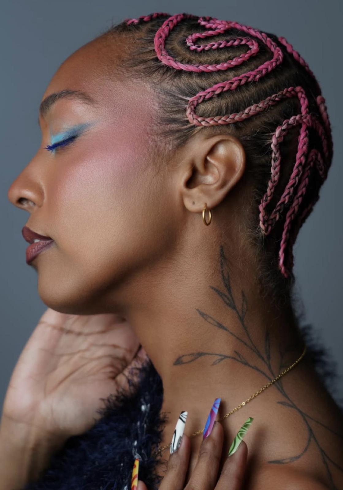 Profile portrait, pink braids and blue liner, chin lifted