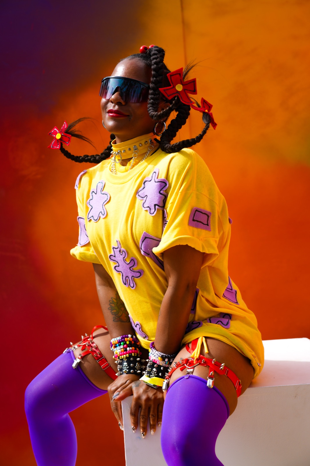Portrait in a yellow tee and violet tights on a warm orange field
