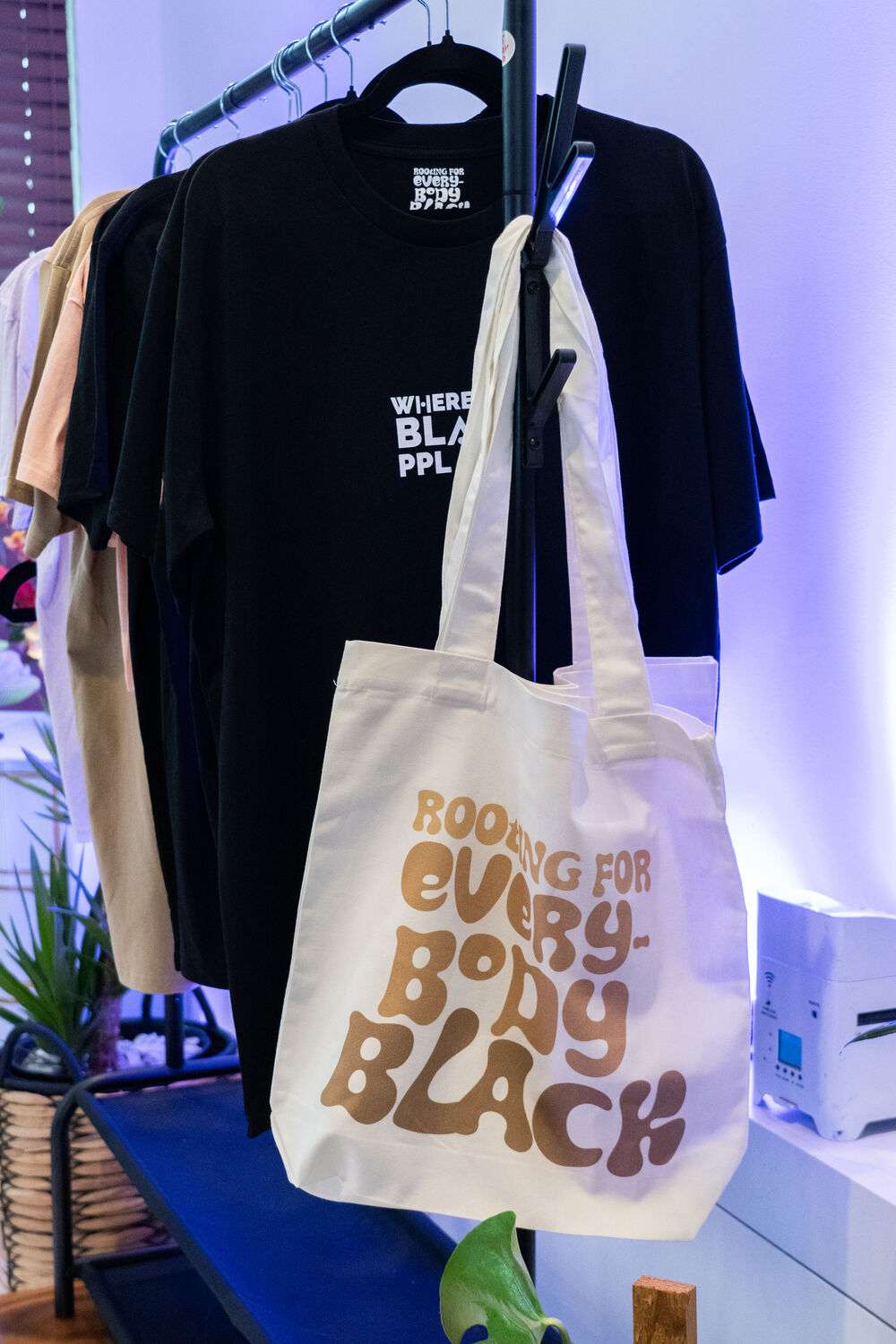 “Rooting For Everybody Black” merch vignette in violet light
