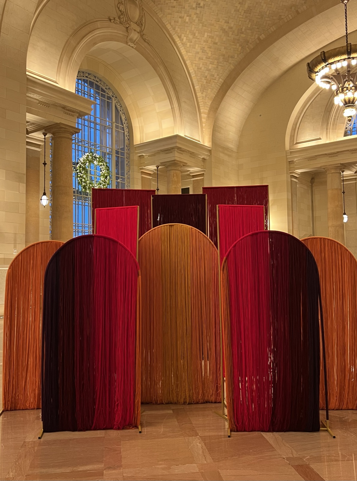 A freestanding yarn portal by Jade Lilly, rainbow fringe poured floor to ceiling